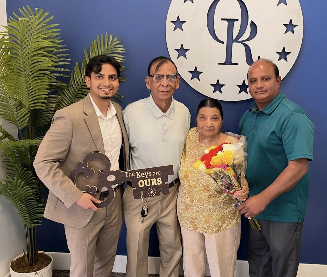 Suhail with a family holding a The Keys Are Ours sign and flowers